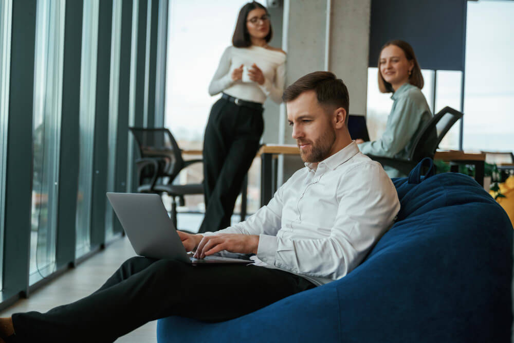 Mann mit Laptop sitz auf Sitzsack